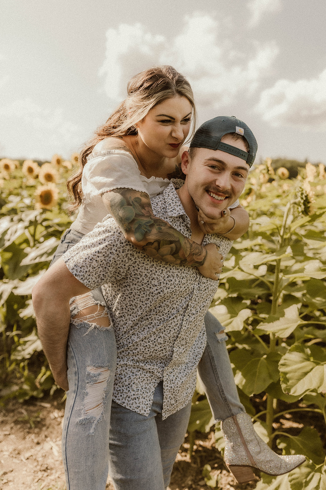 Man giving his fiancee piggyback ride during their romantic and dreamy engagement photoshoot.