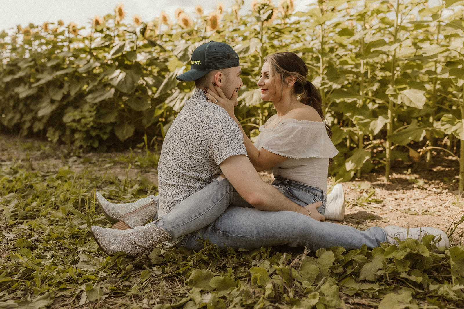 Fun and playful engagement photos in a sunflower field filled with adventurous moments