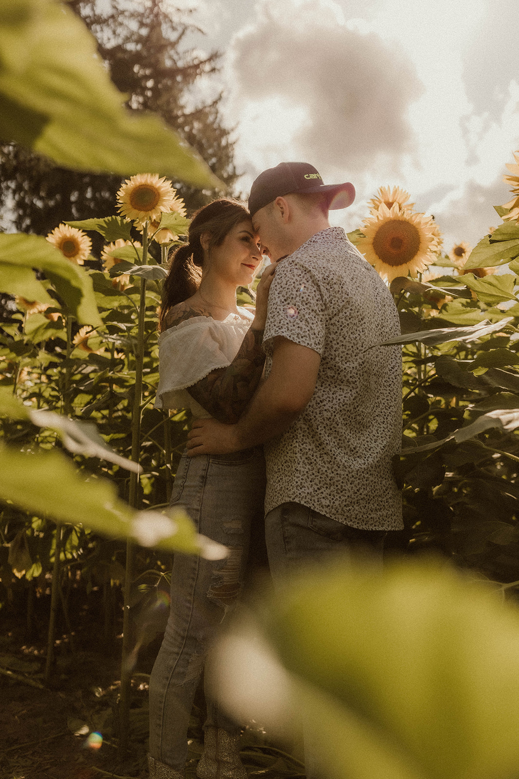 Intimate engagement photoshoot in a sunflower field.