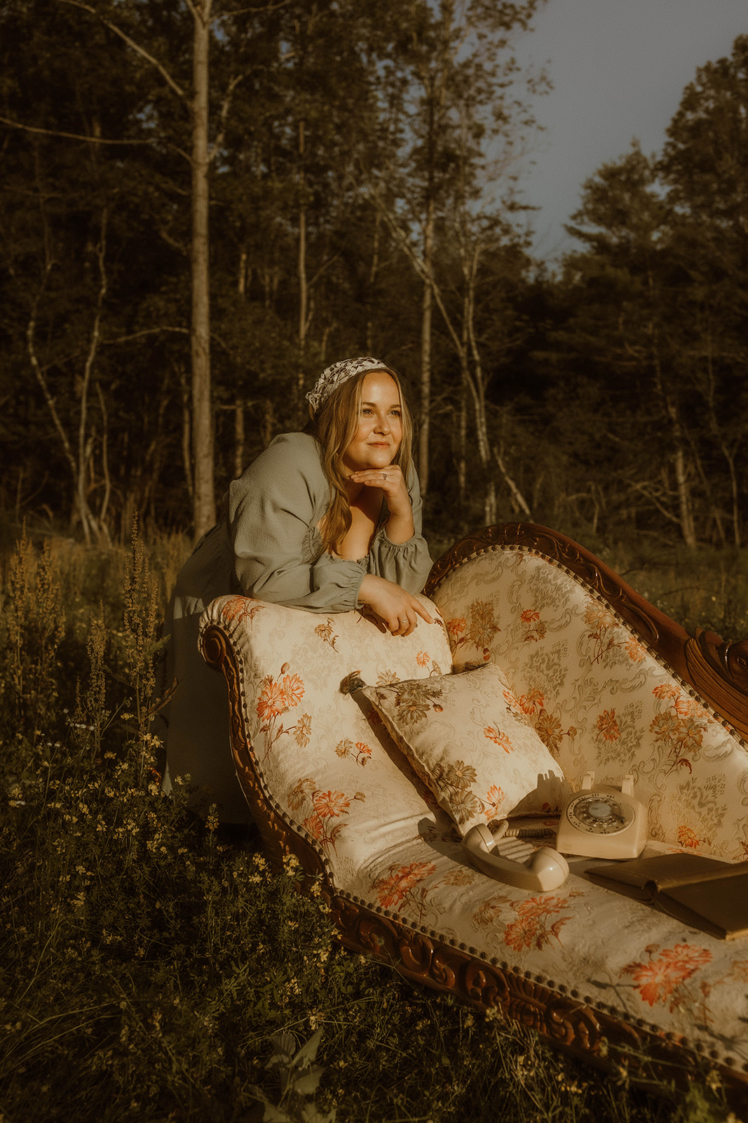 young girl poses with a vintage chaise for creative self portraits in a field