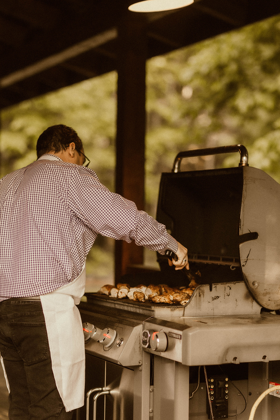 A chef works the grill at the dreamy EBS view lodge nestled in the Adirondack mountains