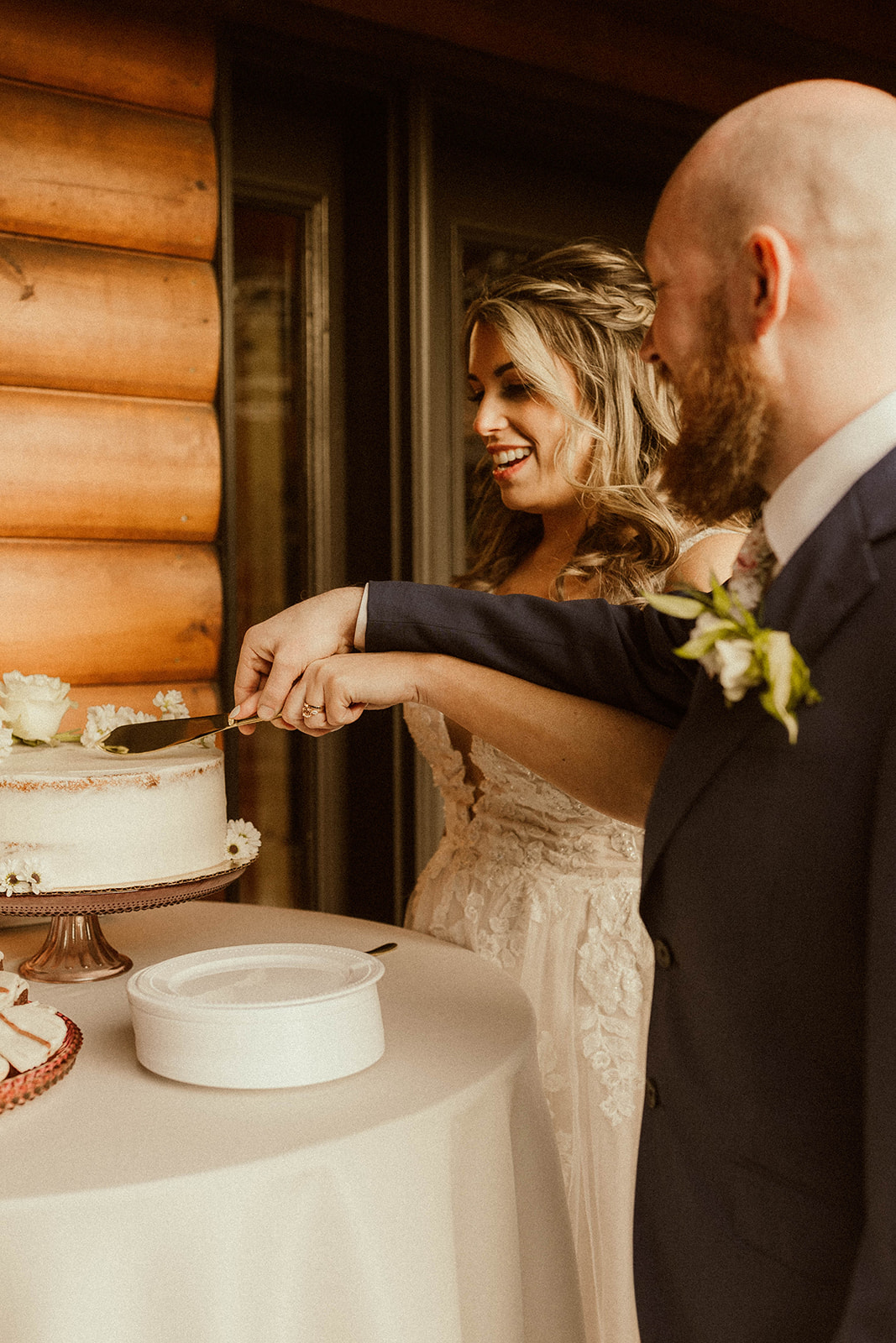 Beautiful bride and groom cut their wedding cake at EBS view lodge nestled in the Adirondack mountains