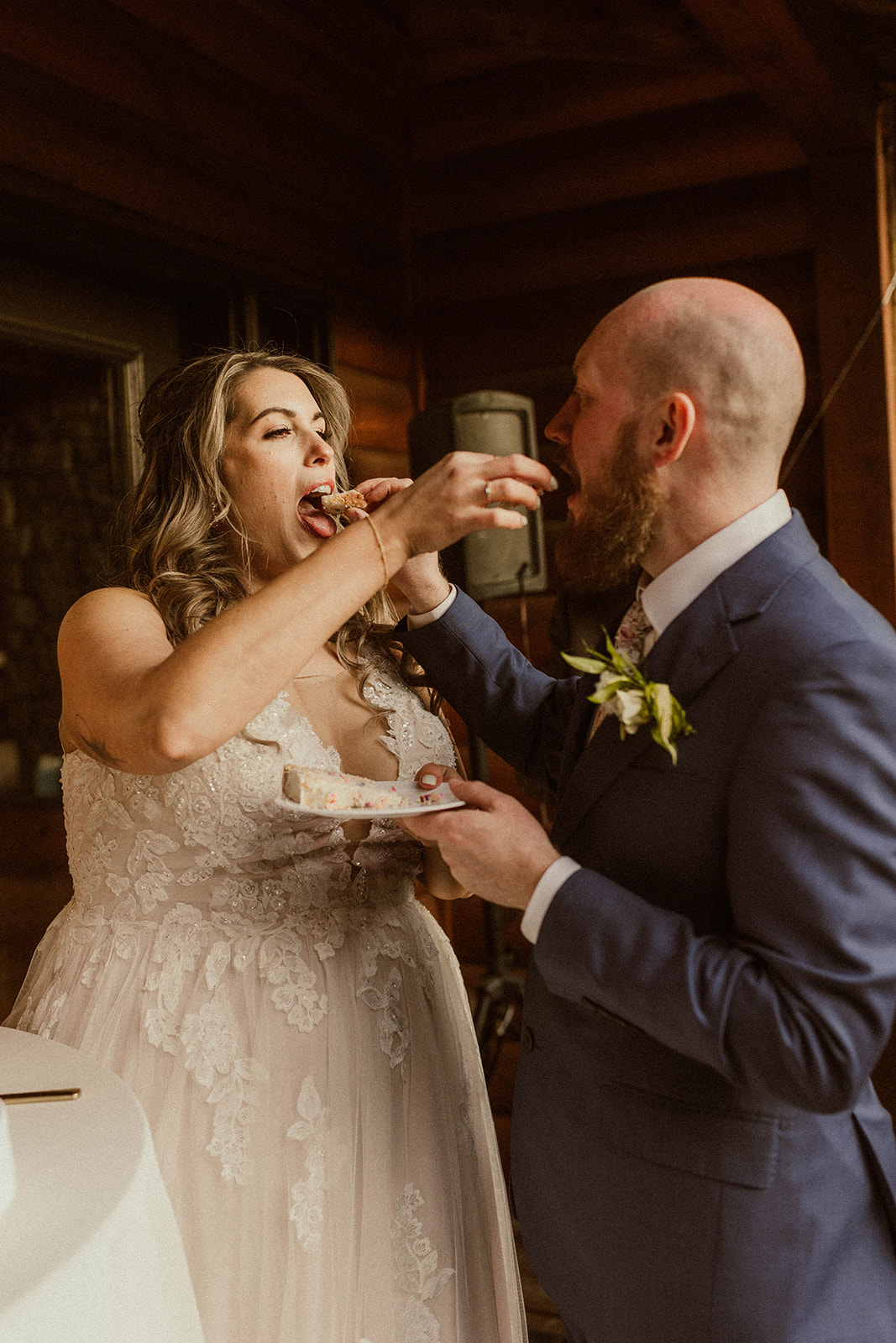 Stunning bride and groom feed each other a cake during their wedding reception at EBS view lodge