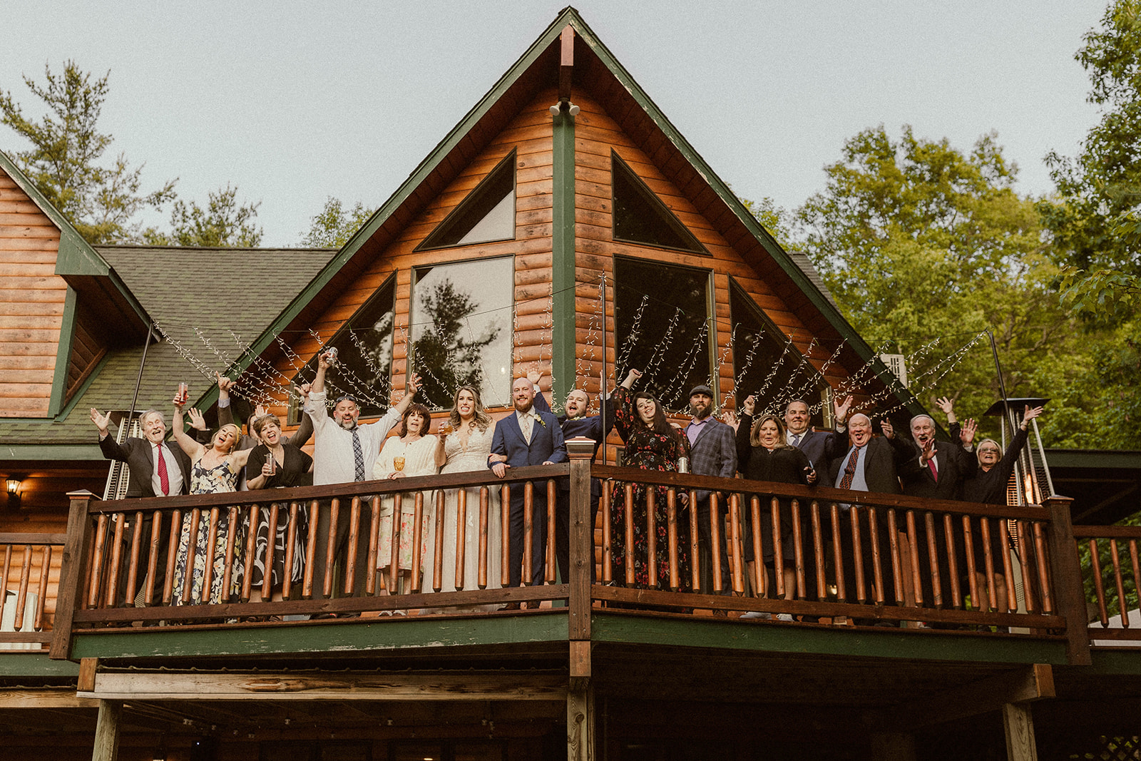 Wedding party poses on the front porch of the stunning A-frame cabin at EBS view lounge