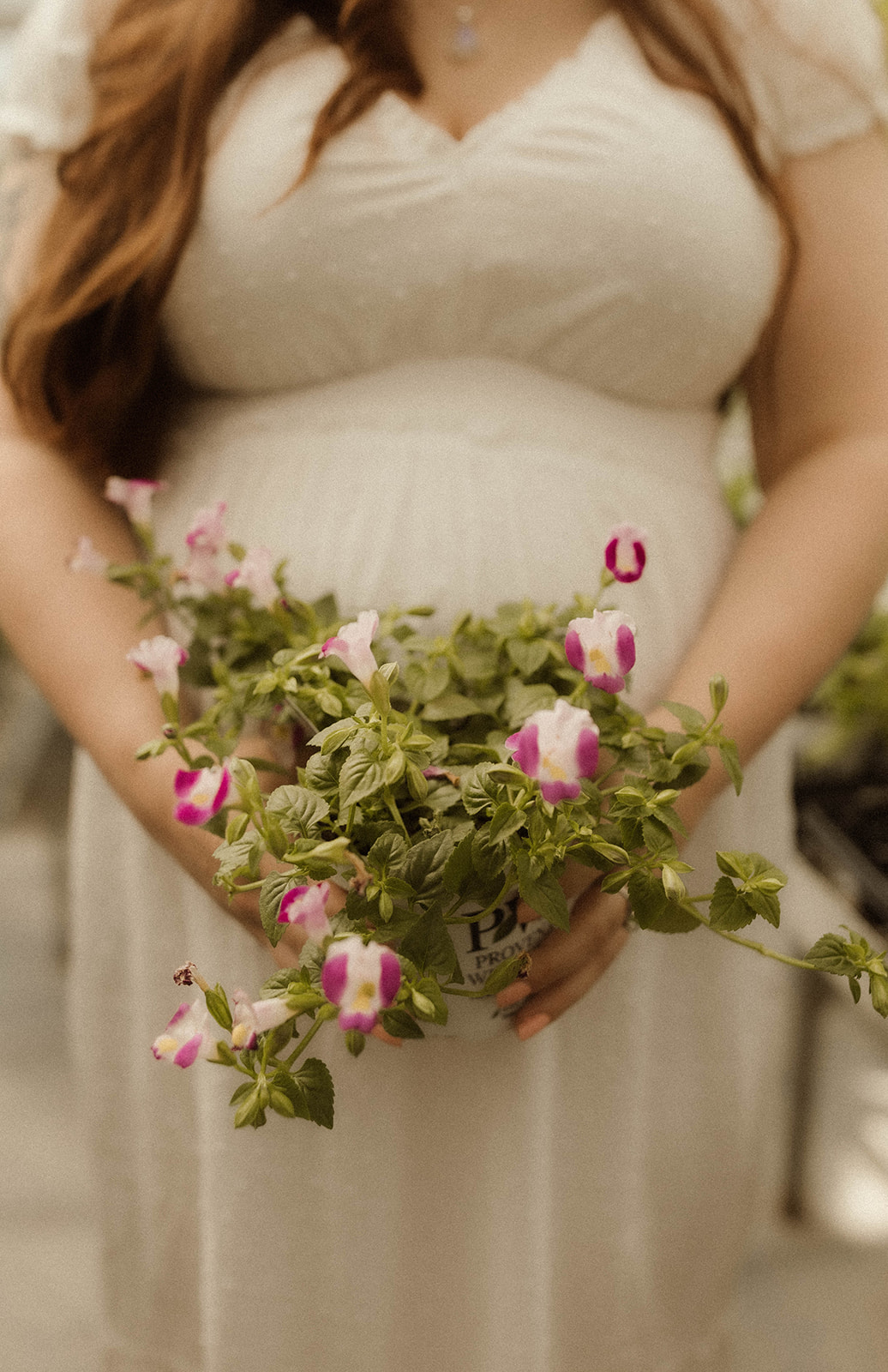 Stunning soon to be mother poses with a flower bouquet during her unique maternity shoot