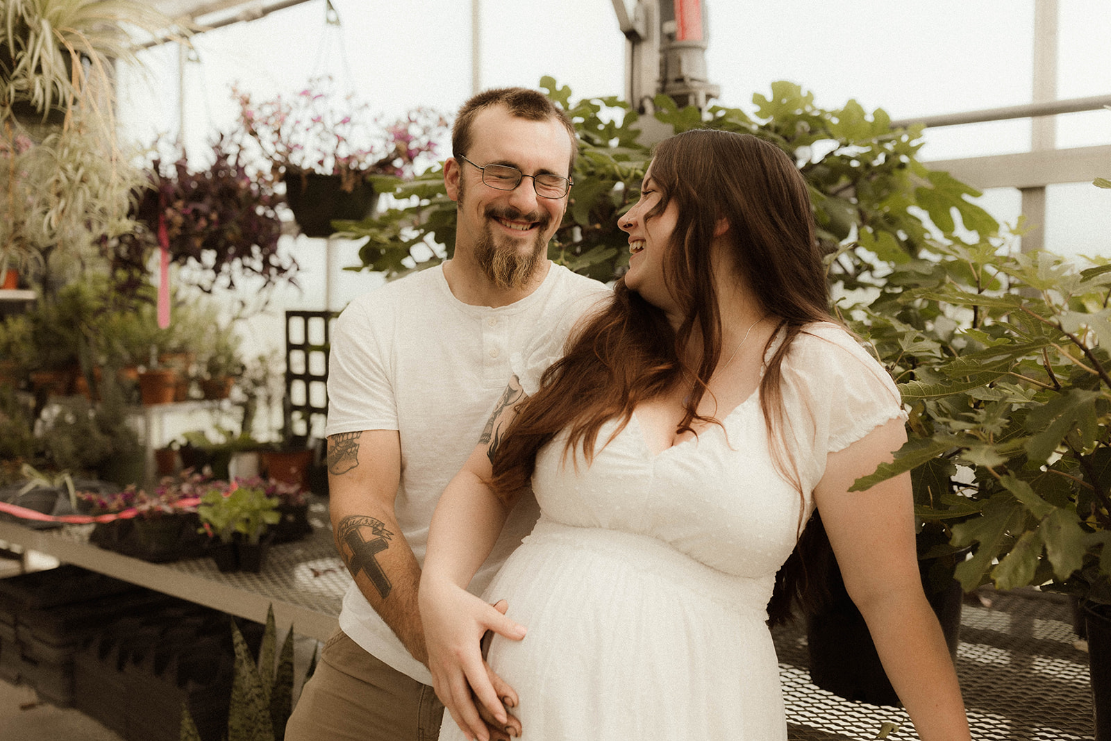 Stunning soon to be mother and father laugh during their unique nursery maternity shoot