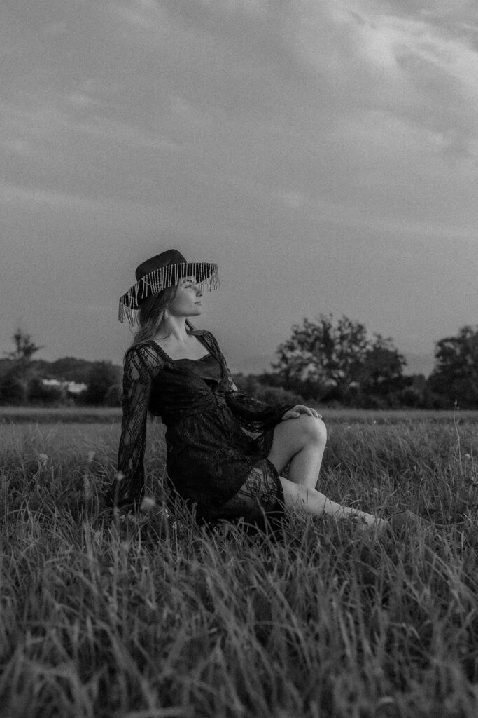 western woman wearing a cowgirl hat in wilfdflower field.