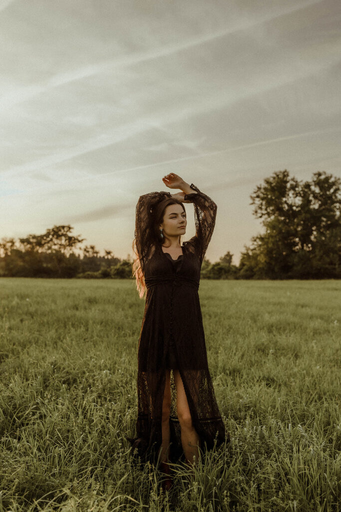 western woman with black dress  standing in wildflower field.
