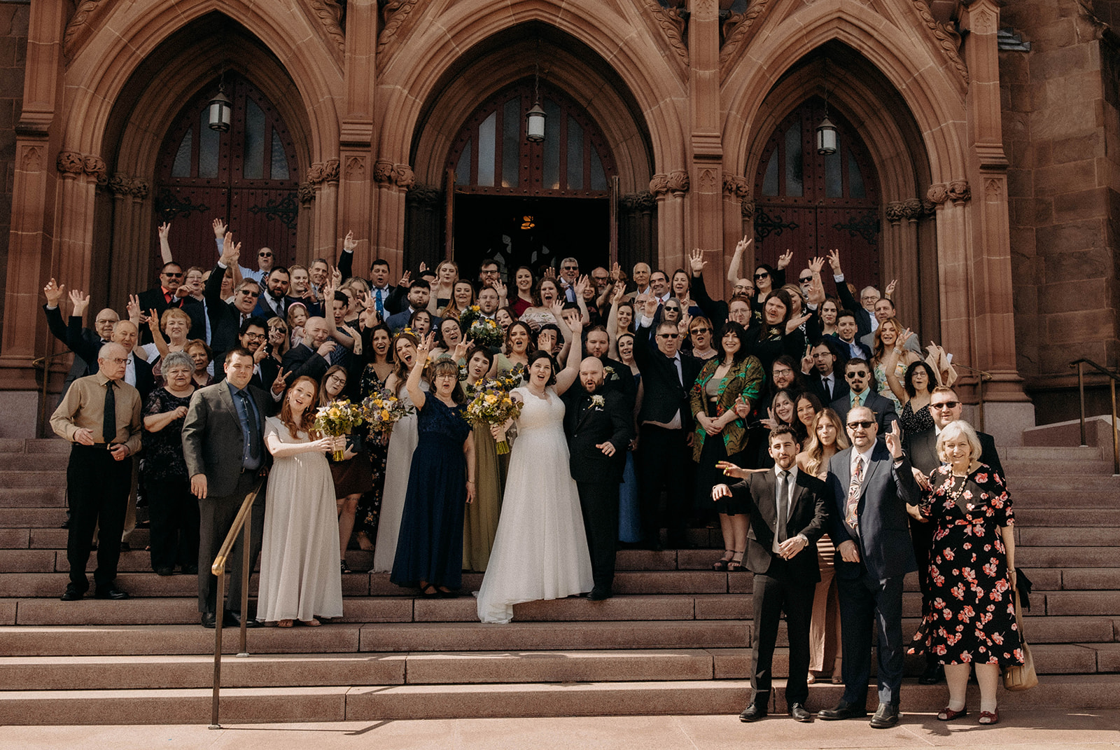 The wedding party groups together to pose together on the upstate New York wedding venue