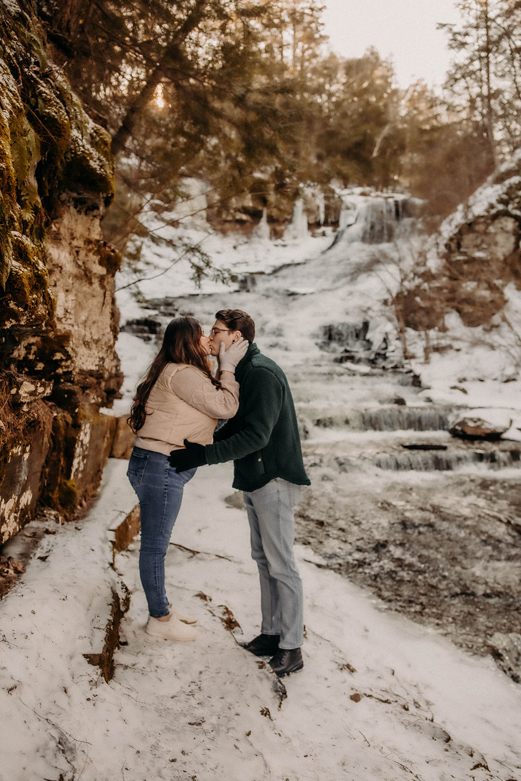 Couple share a kiss in the snow during their winter engagement photoshoot!!
