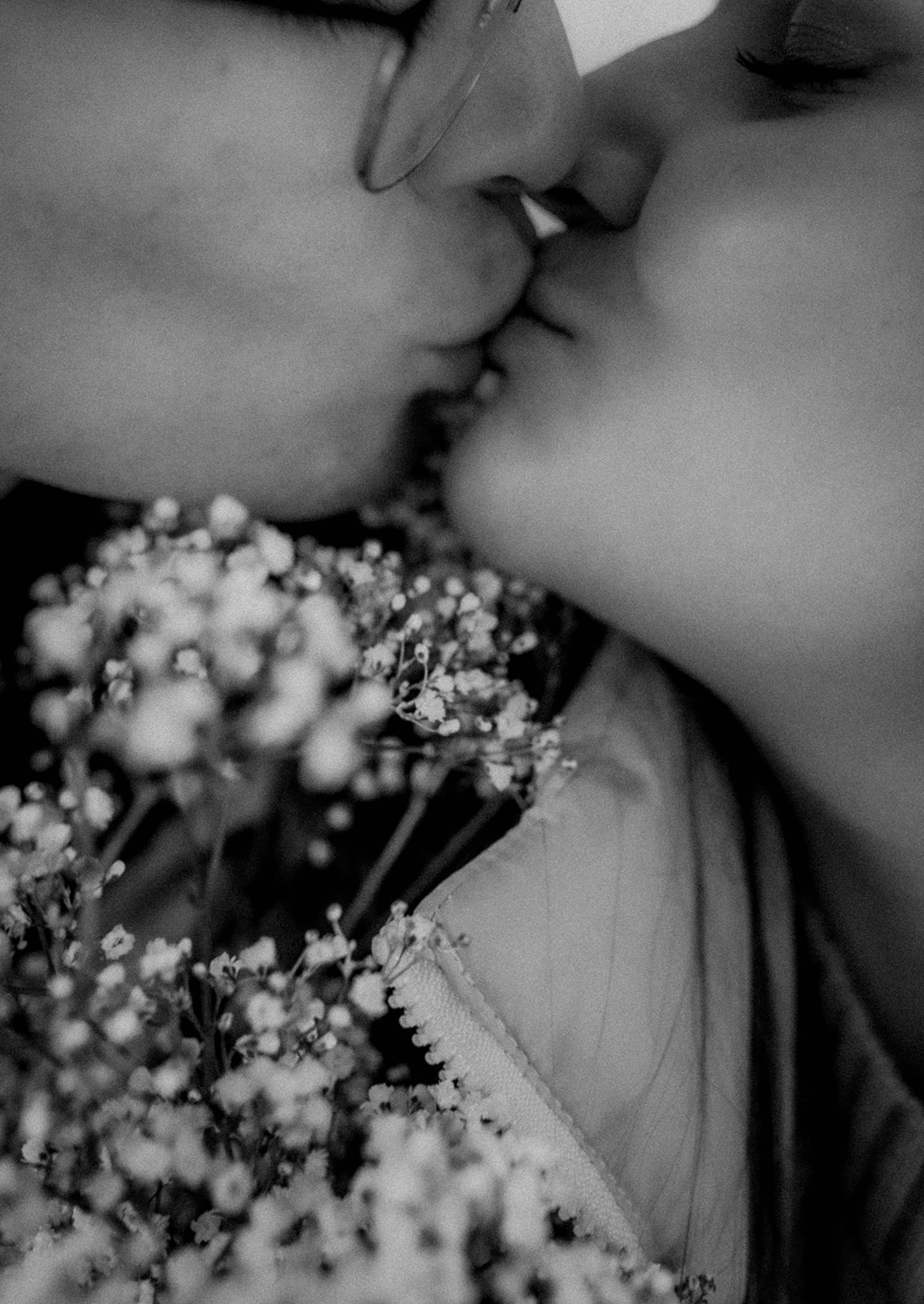 Couple share a kiss over some wildflowers during their stunning winter engagement photoshoot!