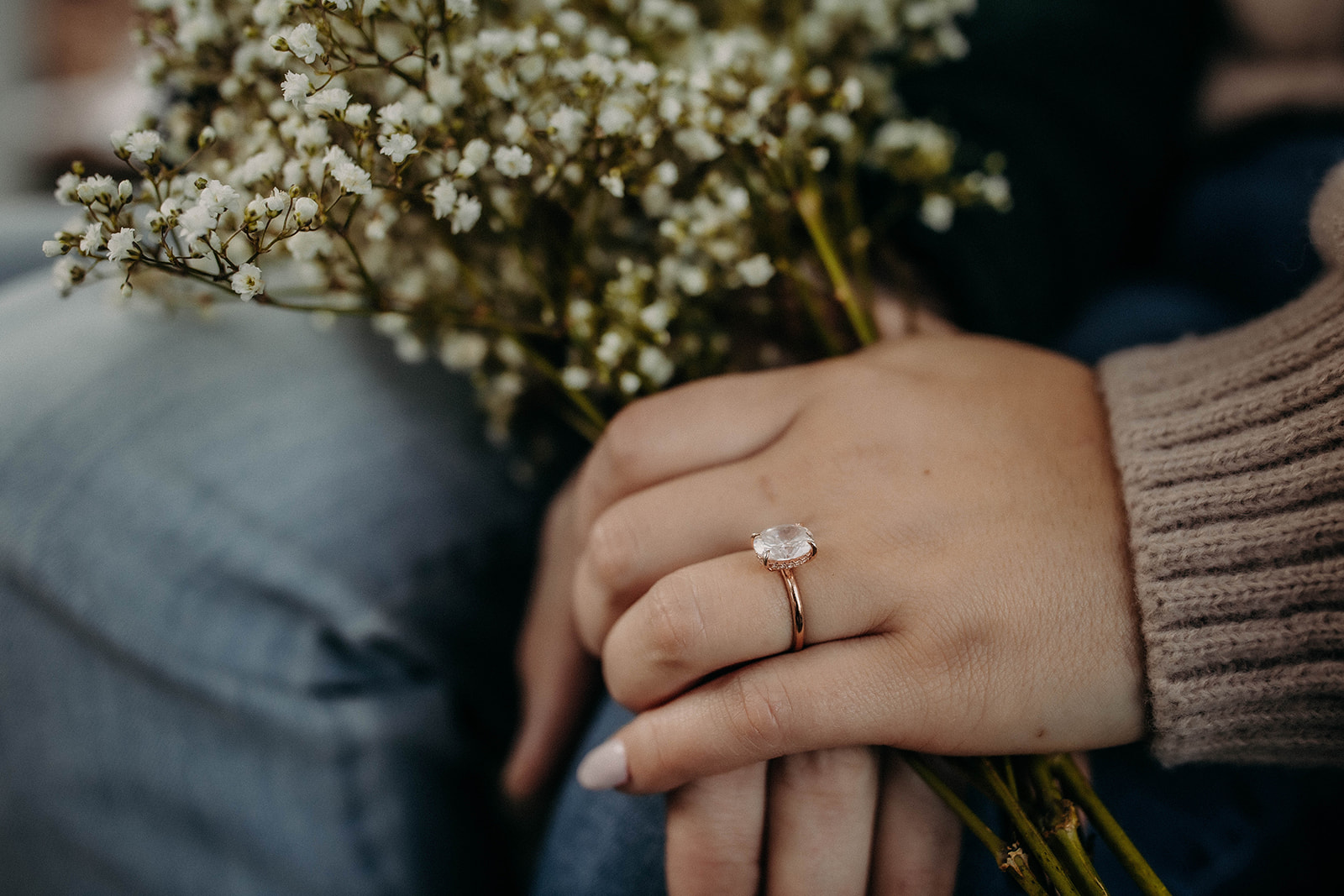Ring and wildflowers during a stunning snowy winter engagement photoshoot