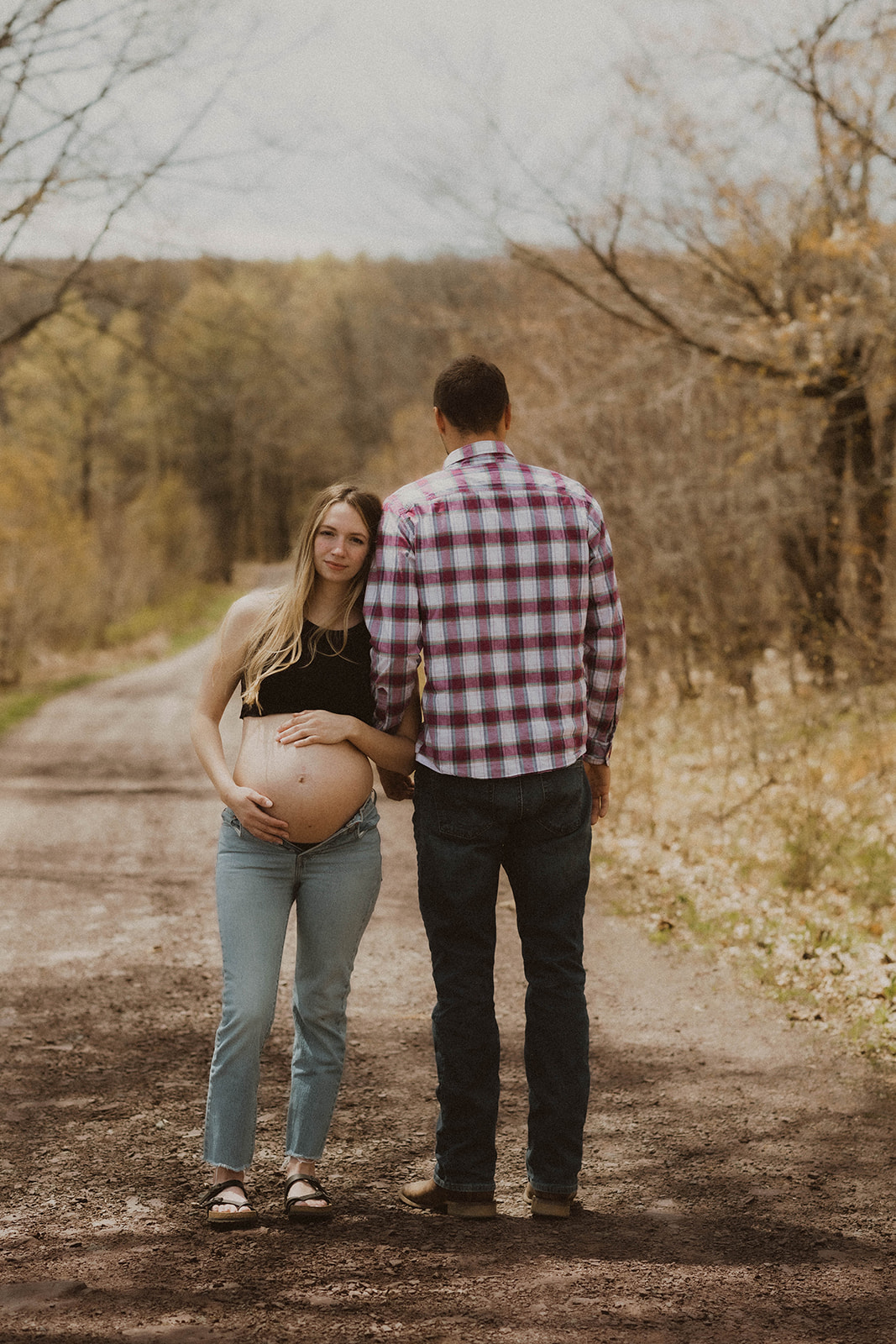 Future parents pose intimately together on a road 