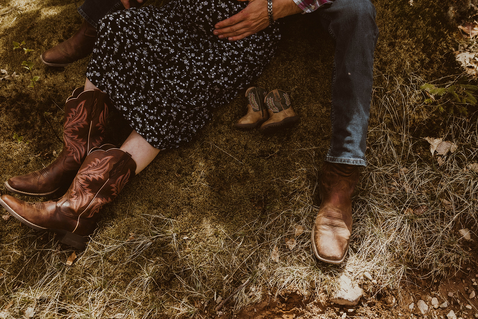 A detail shot of a future mom, dad and sons boots during their beautiful maternity photoshoot