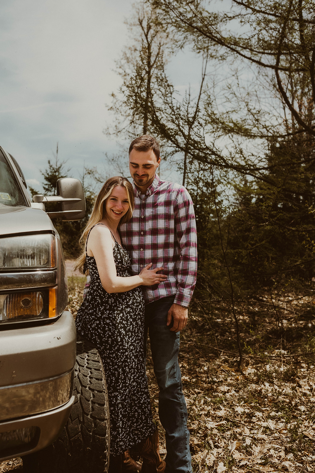 Future parents pose leaning together against their truck during their dreamy upstate New York maternity photos 