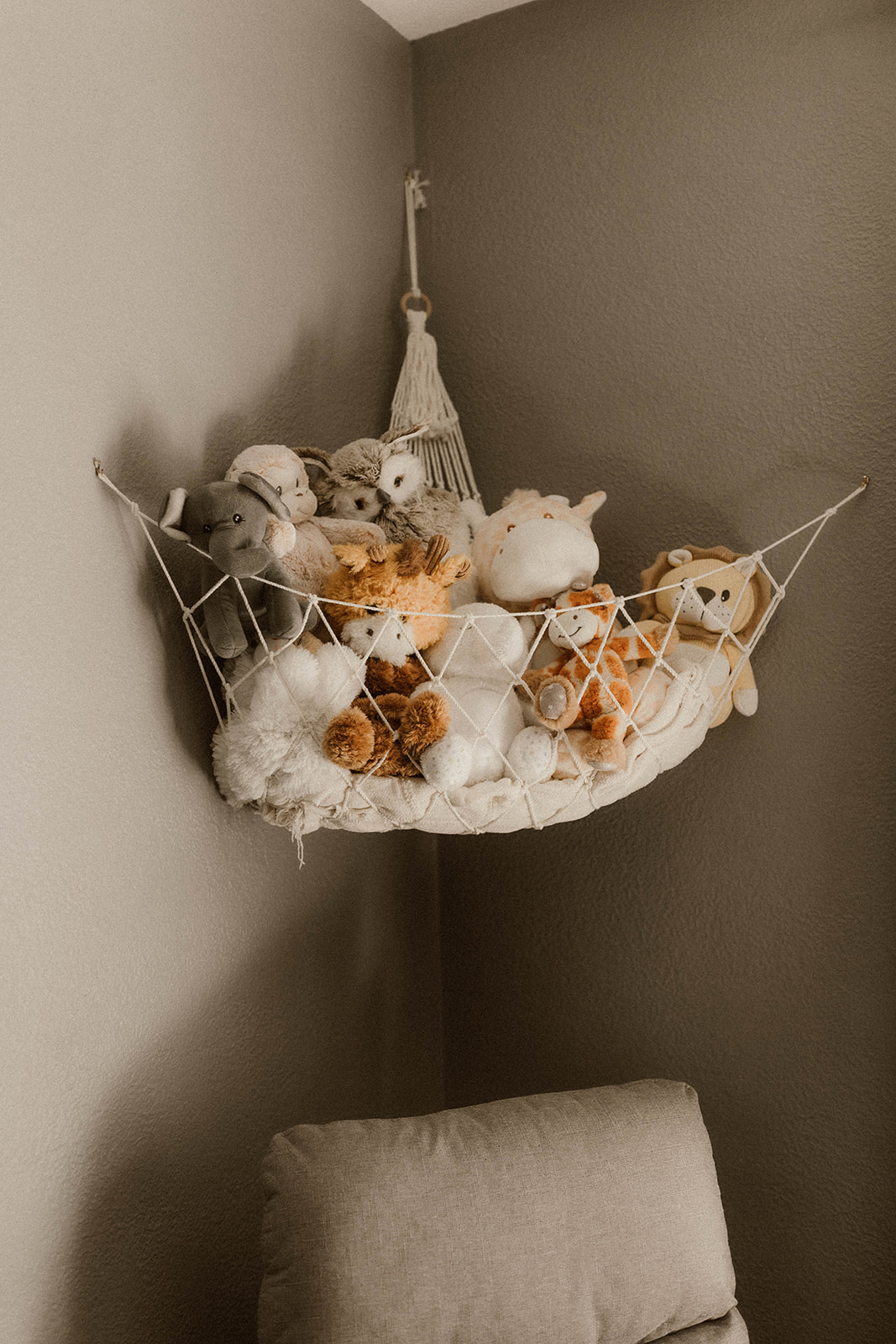 Detail photo of the newborns stuffed animal hammock above his crib 