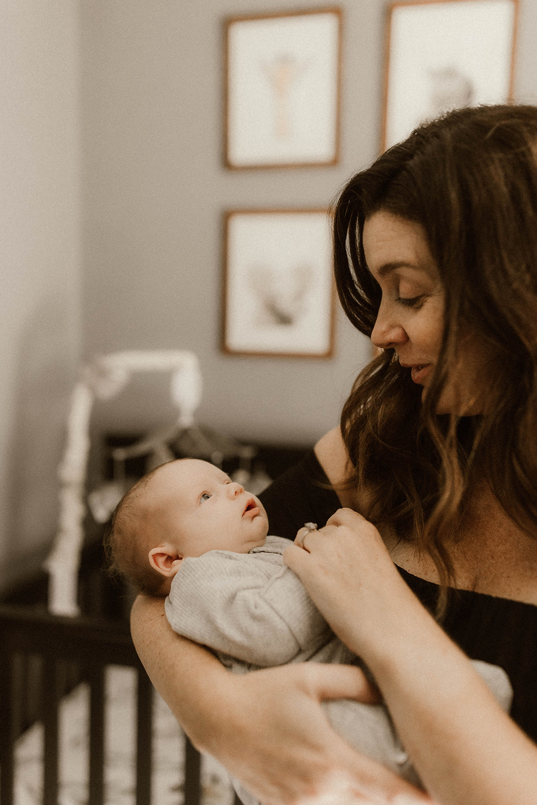 Stunning new mom poses with her son during their dreamy in home newborn family photoshoot