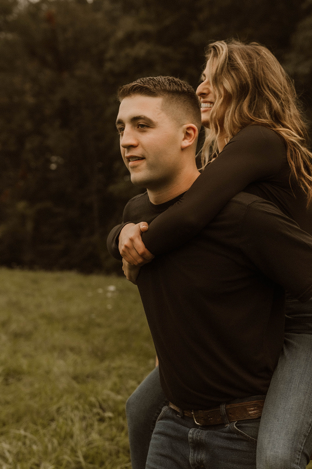 Handsome man gives his beautiful fiancé a piggyback ride during their dreamy upstate New York autumn engagement photos 