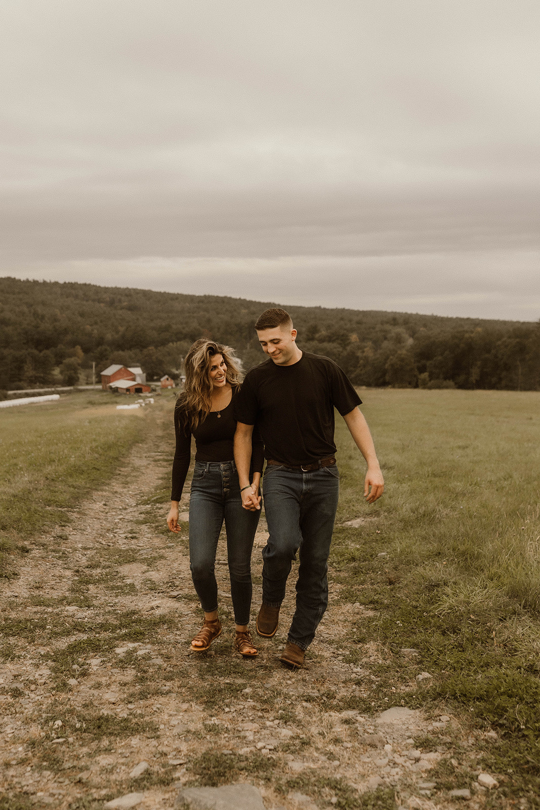 Beautiful couple walk together and sharing a laugh during their dreamy upstate New York engagement photos