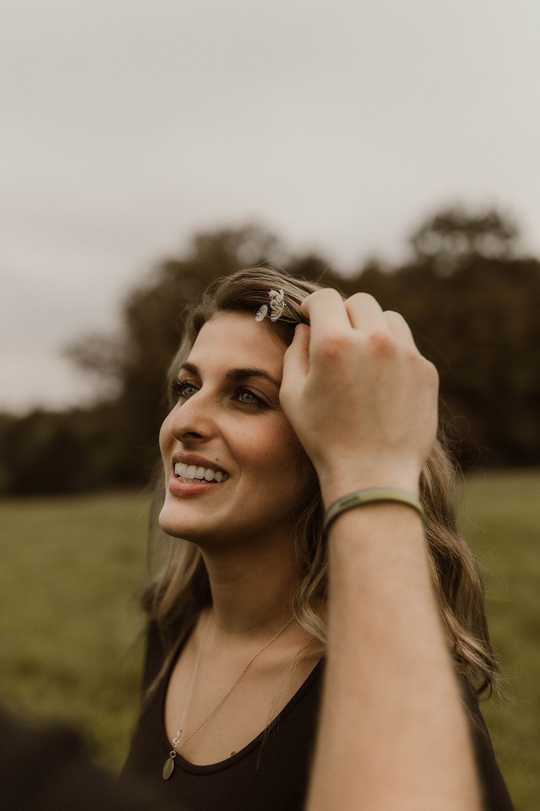 Stunning lady gets a wildflower gently placed behind her ear 