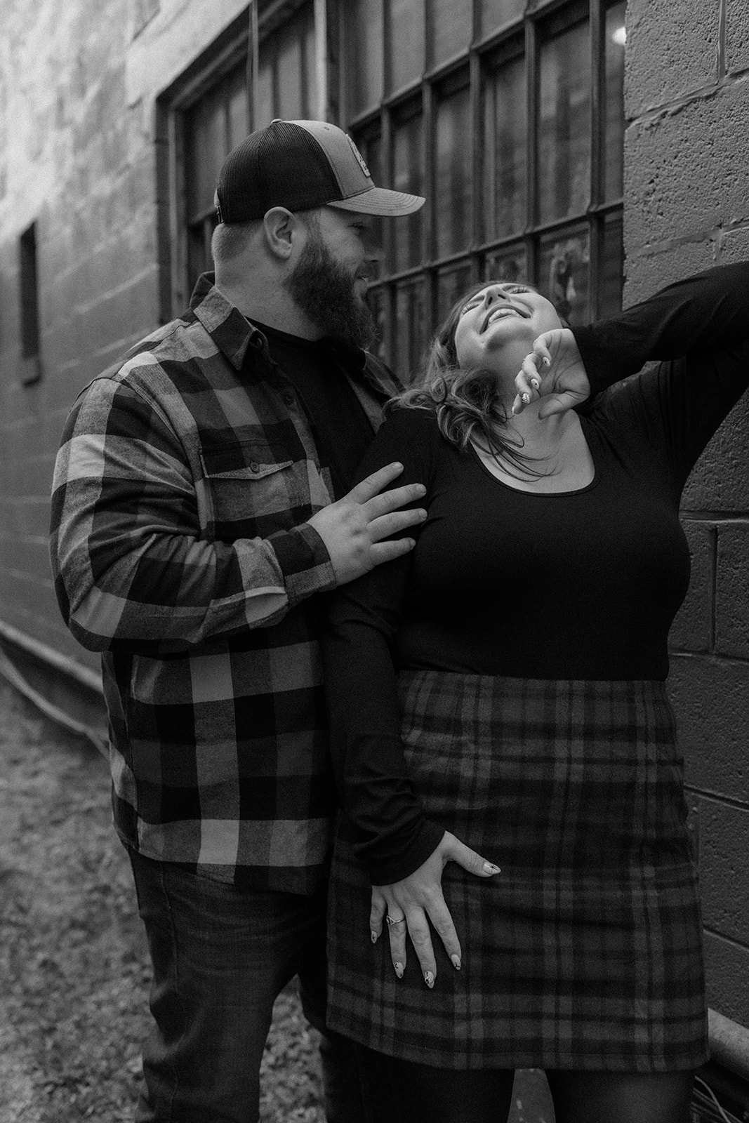 Stunning couple pose together down town during their upstate New York engagement photos