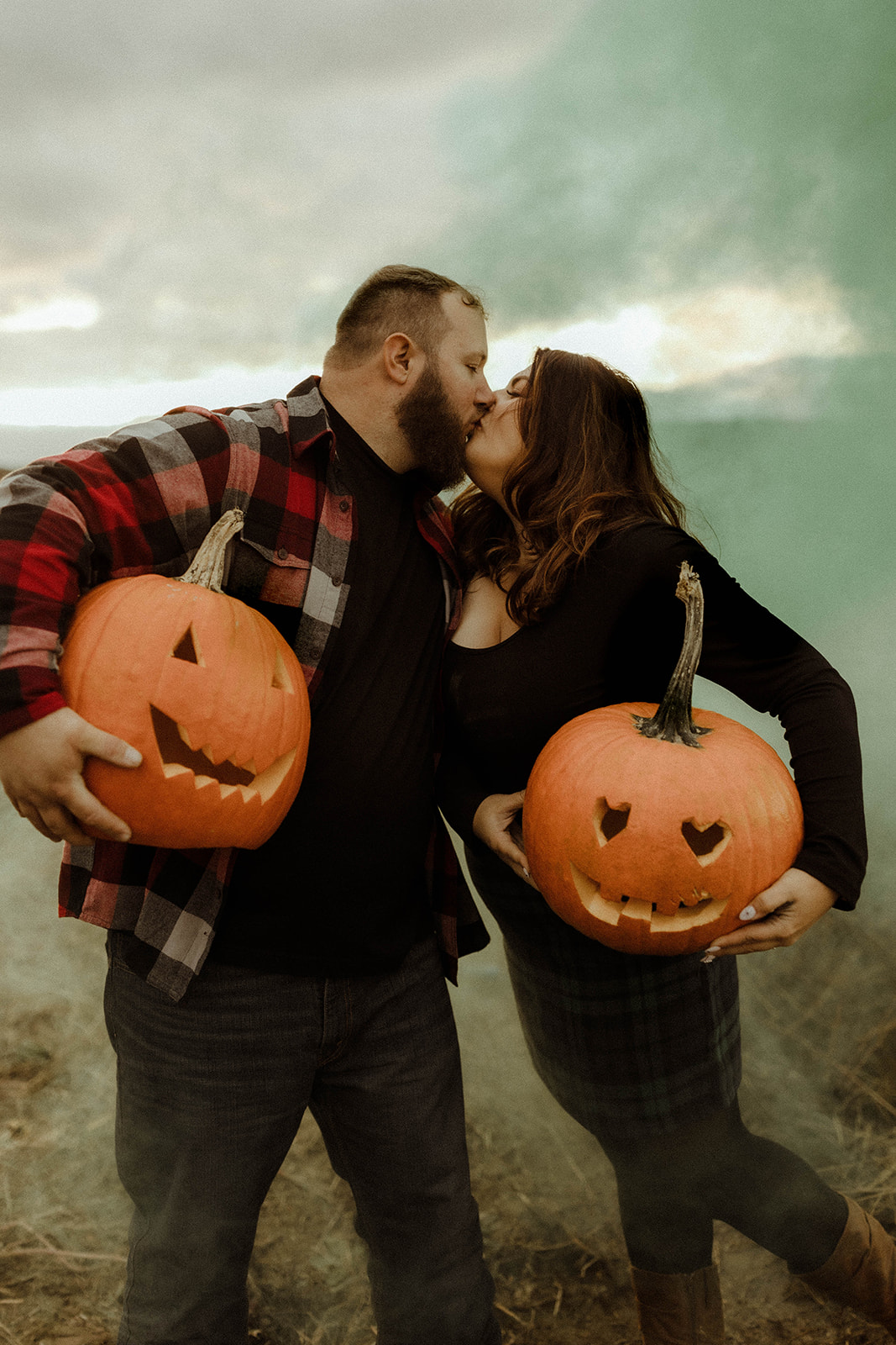 couple pose in a pumpkin patch during their upstate New York engagement photos