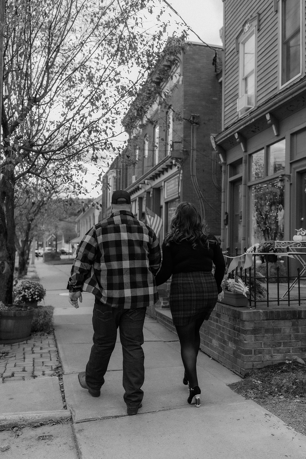 Beautiful couple pose together down town during their upstate New York engagement photos