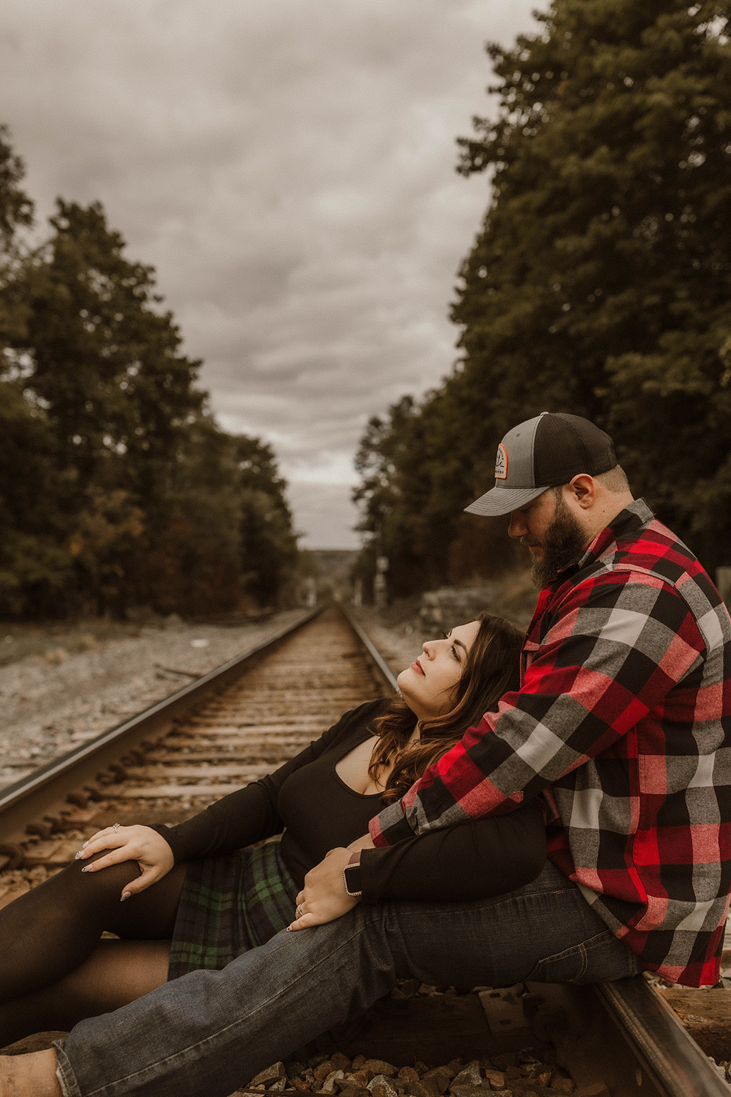 Dreamy couple pose on the railroad tracks together their upstate New York engagement photos