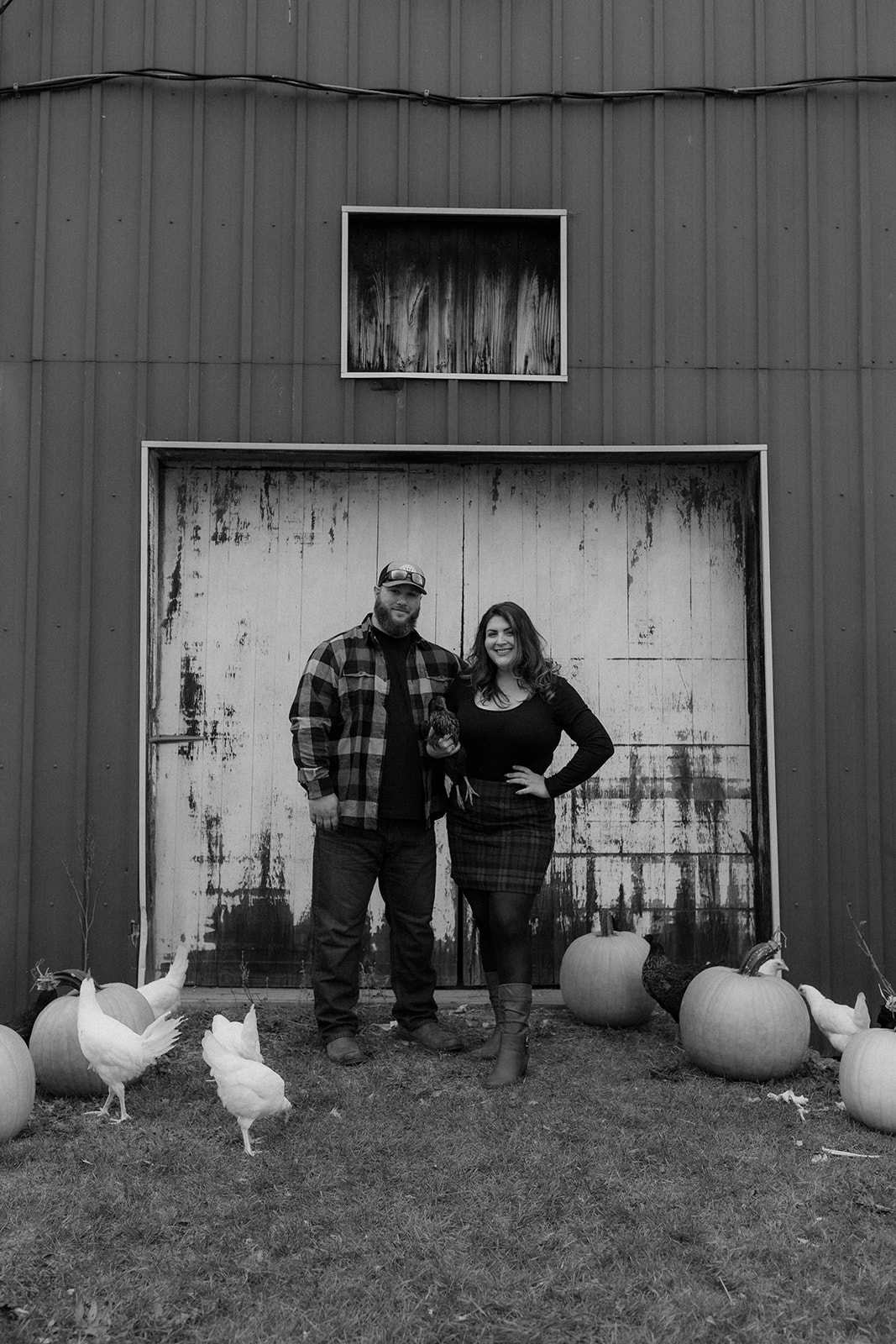 Stunning couple pose together with their chickens during their farm engagement photos