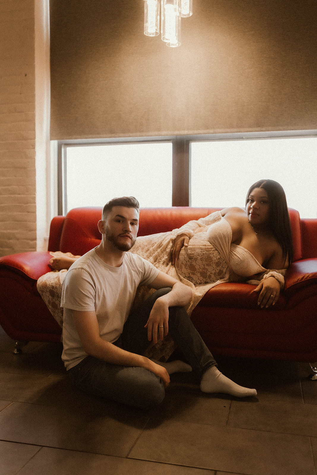 Couple sitting indoor during maternity session.